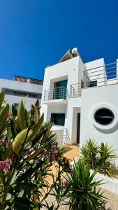 une maison blanche avec des plantes devant elle dans l'établissement Casa "Vento" Ferragudo mit privatem Pool, à Ferragudo