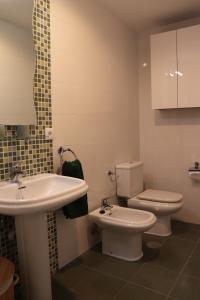 a bathroom with a white sink and a toilet at Oliveira de Portosín in Portosin +68 photos