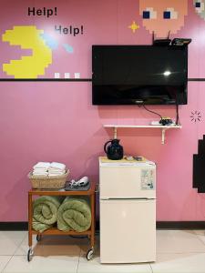 a tv on a wall next to a refrigerator at 斑比Bambi in Tainan