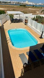 une grande piscine bleue sur une terrasse dans l'établissement Casa "Vento" Ferragudo mit privatem Pool, à Ferragudo