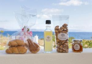 a table with bread and a bottle of oil and other foods at Oinoni's Home - XANTHIPI studio in Souvala