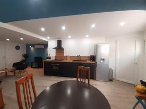 kuchnia i salon ze stołem i lodówką w obiekcie Appartement 50m2 rez de chaussée en plein centre ville garage gratuit w mieście Valras-Plage