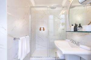 فندق كلاريدج باريس في باريس: حمام أبيض مع دش ومغسلة