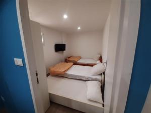 mały pokój z dwoma łóżkami i telewizorem w obiekcie Appartement 50m2 rez de chaussée en plein centre ville garage gratuit w mieście Valras-Plage