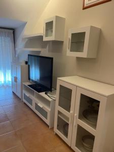 a living room with a television and white cabinets at Apartamento Portela in Bueu