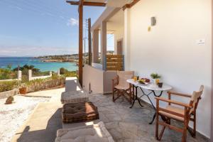 a patio with a table and chairs and the ocean at Oinoni's Home - ALEXANDROS in Souvala
