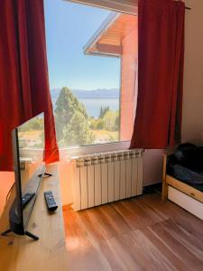 a living room with a large window and a television at Astrolabio Hostel in San Carlos de Bariloche