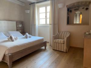 a bedroom with a bed and a chair and a window at Agriturismo Costa di Faraggiana in Levanto