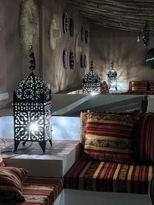 a room with three lamps and a table with pillows at Riad Sahara Activity in Mhamid