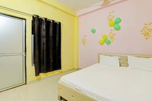 Bhauli的住宿－OYO Hotel Golden Grand，一间卧室设有一张床,墙上设有一扇带气球的窗户。