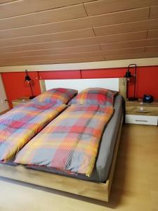 ein Bett mit zwei Kissen auf einem Zimmer in der Unterkunft Am Lindenbaum, Ferienwohnung in Siebenbach am Nürburgring in Siebenbach