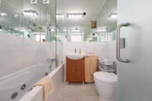 ein Badezimmer mit einem WC, einer Badewanne und einem Waschbecken in der Unterkunft Fábrica da Ribeira 80 by Destination Algarve in Lagos