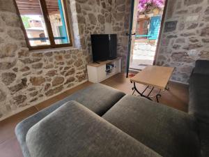 sala de estar con sofá y TV en Stone House Knezevic, en Vinjerac