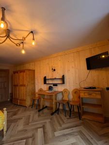 a room with a wooden wall with a table and chairs at Pokoje Cichy Kącik in Zakopane