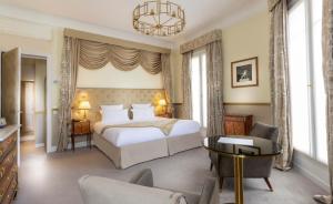 a bedroom with a bed and a table and chairs at Hotel Claridge Paris in Paris