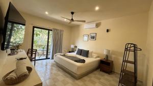 a bedroom with a bed and a television in it at Hotel Casa Barbara Holbox in Holbox Island