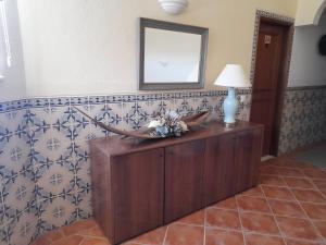 a room with a table with a lamp and a mirror at Aurora Sol in Luz