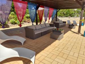 a patio with a couch and chairs and flags at Aurora Sol in Luz