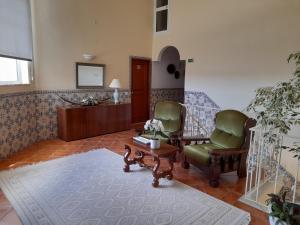 a living room with two chairs and a table at Aurora Sol in Luz