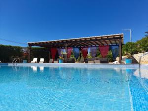 duży basen z pergolą na górze w obiekcie Aurora Sol w mieście Luz
