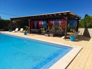 a swimming pool with a gazebo and a swimming pool at Aurora Sol in Luz