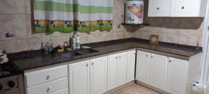 a kitchen with white cabinets and a sink at Don Manuel in Santa Rosa +1 photo