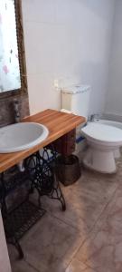 a bathroom with a toilet and a table and a sink at Don Manuel in Santa Rosa