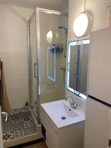 uma casa de banho branca com um chuveiro e um lavatório. em Appartement T4 à deux pas de la gare St Charles em Marselha