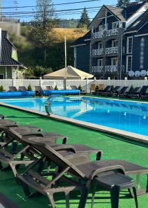 a large swimming pool with chairs in front of a building at Mirage in Bukovel