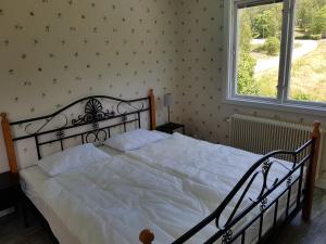 a bedroom with a large bed with white sheets and a window at Landhaus Lönneberga in Lönneberga +11 photos