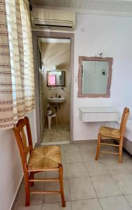ein Wohnzimmer mit einem Spiegel und einem Stuhl in der Unterkunft Marina In Town in Megali Ammos