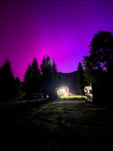 a purple sky at night with a campsite at Cicha Dolina in Cisna