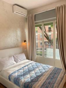 a bedroom with a bed and a large window at Guest House Romoli in Rome