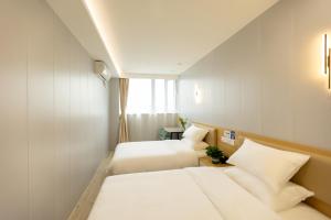 pokój hotelowy z 2 łóżkami i oknem w obiekcie KeTangJian Aparthotel w Szanghaju