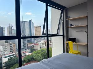 une chambre avec un lit et une chaise jaune dans l'établissement Loft Xolo CDMX, à Mexico 31 autres photos