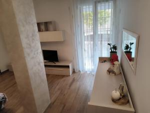 een witte woonkamer met een bureau en een spiegel bij CARLA' S HOUSE in Anzola dell'Emilia