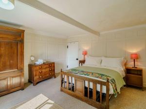 a bedroom with a large bed and a wooden dresser at 5 Bed in Broughton Beck SZ587 in Spark Bridge
