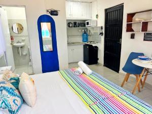 a white bed in a room with a kitchen at "Casitas Arcoiris" Excelente ubicación - Petfriendly in Isla Mujeres +53 photos