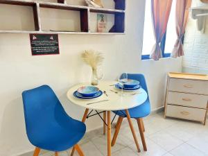 une table avec deux chaises bleues et une table blanche avec une plaque dans l'établissement "Casitas Arcoiris" Excelente ubicación - Petfriendly, à Isla Mujeres