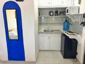 - une petite cuisine avec une porte bleue dans une chambre dans l'établissement "Casitas Arcoiris" Excelente ubicación - Petfriendly, à Isla Mujeres
