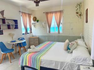 - une chambre avec un lit, une table et des chaises dans l'établissement "Casitas Arcoiris" Excelente ubicación - Petfriendly, à Isla Mujeres
