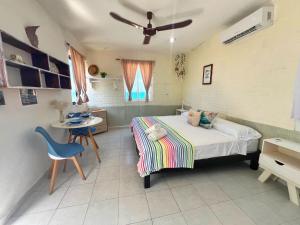 - une chambre avec un lit, une table et une chaise dans l'établissement "Casitas Arcoiris" Excelente ubicación - Petfriendly, à Isla Mujeres