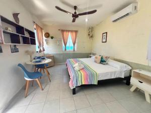 a bedroom with a bed and a table and a chair at "Casitas Arcoiris" Excelente ubicación - Petfriendly in Isla Mujeres