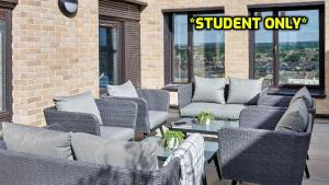 a patio with wicker chairs and a table with pillows at Student Only Zeni Ensuite Rooms, Southampton in Southampton