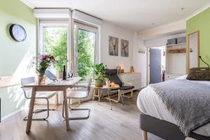 1 dormitorio con cama, escritorio y mesa en Cozy House - fietsverhuur, eigen keuken en badkamer en Nijmegen
