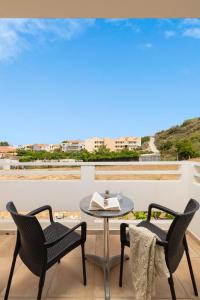 un patio con 2 sillas y una mesa en el balcón en Thelèsi Apartments, en Stalós
