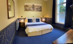 a bedroom with a large bed with blue carpet at Atlantis Holiday Apartments in Torquay +113 photos