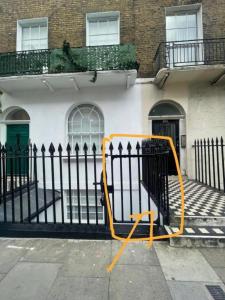 un objet jaune penche contre une clôture dans l'établissement Lovely flat in Baker street, à Londres