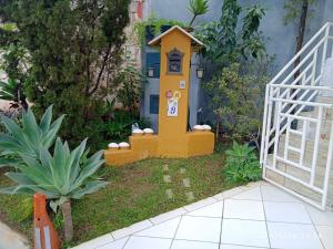 un giardino con una piccola casa nel cortile di MINHA CASA,SUA CASA a São Bento do Sapucaí