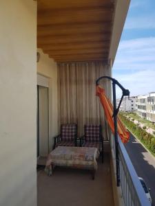 a balcony with a bed and an orange umbrella at Beach-Side 2-BR Oasis with Private Pool & Parking in Casablanca